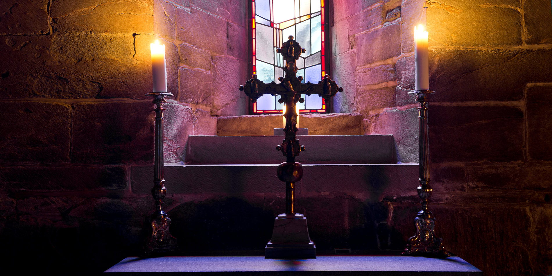The hidden rooms of Nidaros Cathedral. The picture shows a cross and two lit candles inside Nidaros Cathedral