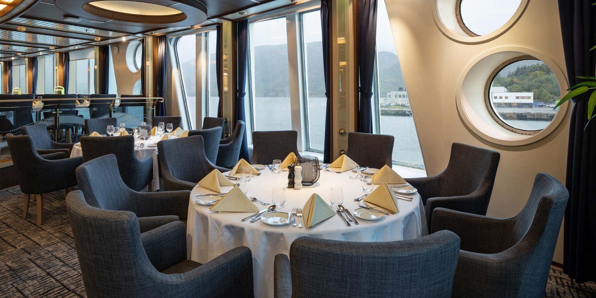 Round table with big windows in hte background  in Aune restaurant onboard MS Fram.