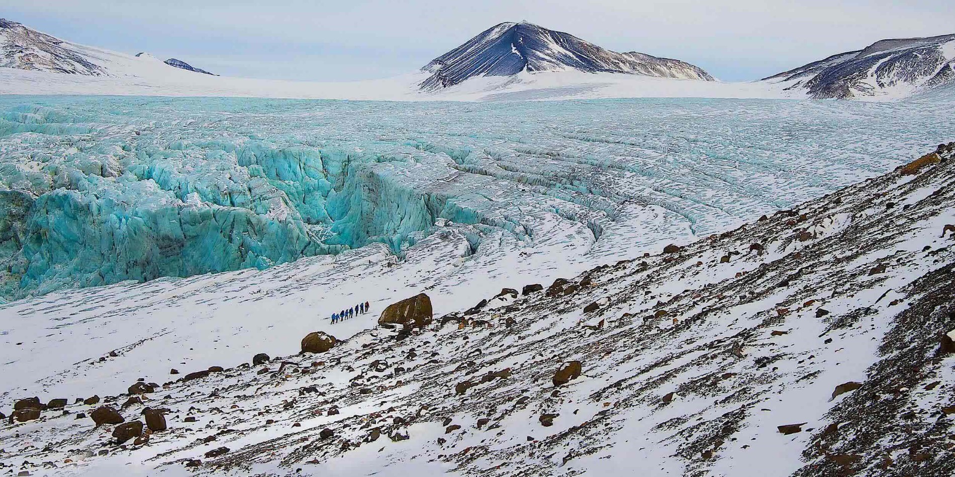Group of tourists dwarfed by a big glacier