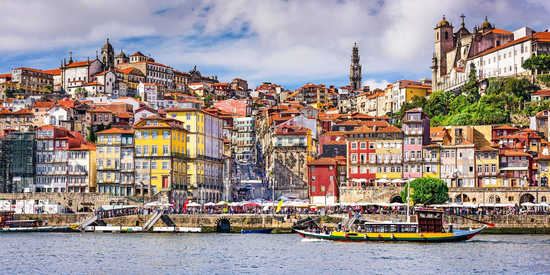 A small boat in a body of water with Porto in the background